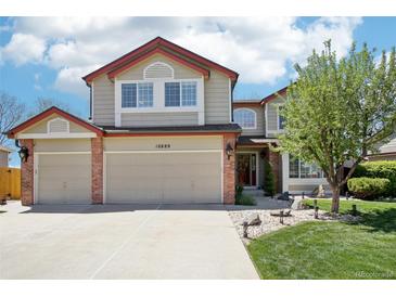 Charming two-story home with a three-car garage, brick accents, and a well-manicured lawn at 10889 Alcott Ct, Denver, CO 80234
