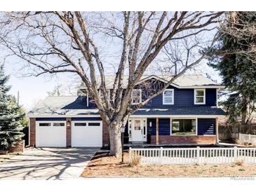 Charming two-story home featuring a two-car garage, brick accents, and a well-maintained front yard at 3100 S Holly Pl, Denver, CO 80222