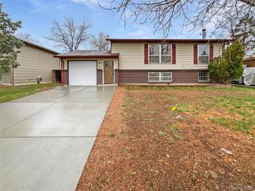 Charming split-level home with a well-maintained front yard and a long, newly paved driveway at 1045 Mobile St, Aurora, CO 80011