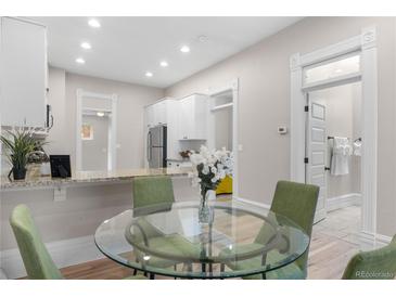 Bright dining area with modern table, chairs and updated kitchen with stainless appliances at 328 E Dakota Ave, Denver, CO 80209