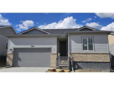 Charming single-Gathering home showcasing a gray exterior, stone accents, and an attached two-car garage at 17085 W 92Nd Loop, Arvada, CO 80007