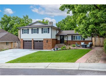 Charming two-story home featuring a well-manicured lawn, brick accents, and a cozy front patio at 14428 W Ellsworth Pl, Golden, CO 80401