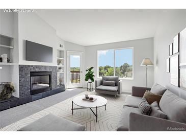 Bright living room features a fireplace, large windows with neighborhood views, and modern furniture at 4286 S Eldridge St # 202, Morrison, CO 80465