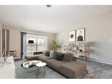 Bright living room with modern furniture and decor, flowing out to a balcony with a view at 720 S Clinton St # 2D, Denver, CO 80247
