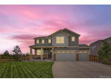 Two-story house with gray siding, stone accents, and a three-car garage at 1489 W 171St Pl, Broomfield, CO 80023