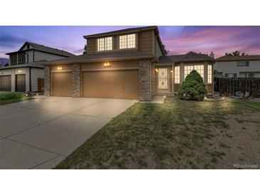 Beautiful two-story home with a three-car garage, stone accents and manicured lawn at 20651 E 42Nd Ave, Denver, CO 80249