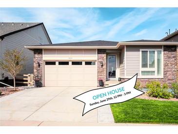 Charming single-story home featuring a two-car garage, stone accents, and a well-manicured lawn at 9055 Swan River St, Littleton, CO 80125