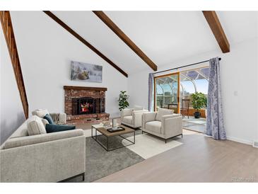 Cozy living room with a brick fireplace, wood beams, and access to a bright sunroom at 7596 Rafter Rd, Franktown, CO 80116