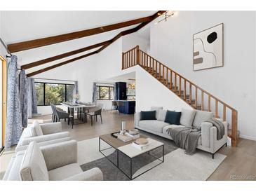 Bright and airy living room featuring vaulted ceilings, wooden beams, and an open floor plan at 7596 Rafter Rd, Franktown, CO 80116