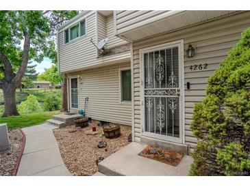 Charming townhome entrance featuring decorative door and manicured landscape at 4262 E Maplewood Way, Centennial, CO 80121