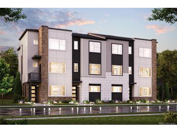 Modern townhome with multi-tone exterior, manicured lawn, and inviting curb appeal at 453 Interlocken Blvd # 104, Broomfield, CO 80021
