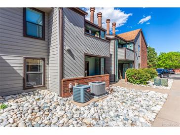 Exterior of home featuring muted siding, brick accents, and a stone garden at 12047 E Harvard Ave # 103, Aurora, CO 80014