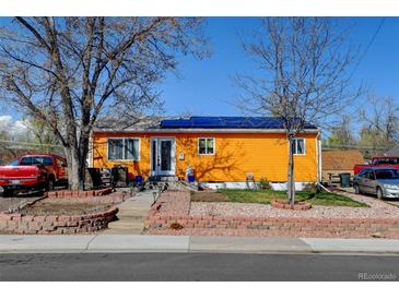 Charming single-story home with a brightly colored exterior, solar panels and well-maintained landscaping at 7970 Wolff Ct, Westminster, CO 80030