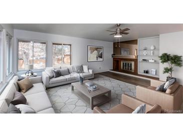 Staged living room with modern furnishings, fireplace, and large windows for plenty of natural light at 53 S Eagle Cir, Aurora, CO 80012