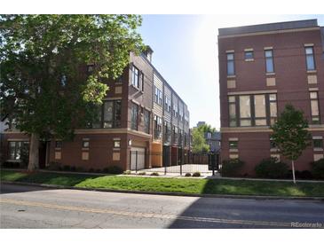 Modern townhomes with red brick exteriors and well-maintained front lawns near a paved street at 2147 N Downing St, Denver, CO 80205