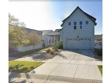 Two-story home features a spacious driveway, attached garage, manicured lawn, and a light-blue exterior at 4628 Mt Shavano St, Brighton, CO 80601