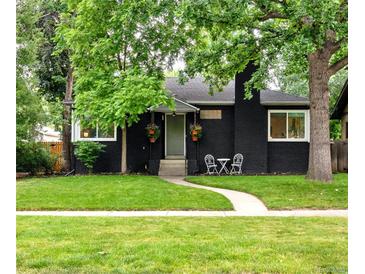 Charming home with a black brick exterior, inviting front yard, and cozy seating area at 1218 S University Blvd, Denver, CO 80210