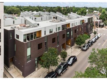 Modern townhome exterior with unique architecture, a rooftop deck, and private entrances on a tree-lined street at 3233 Tejon St # 305, Denver, CO 80211
