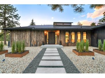 Modern home with rustic wood siding and a stone walkway leading to the front door at 18910 Augusta Dr, Monument, CO 80132