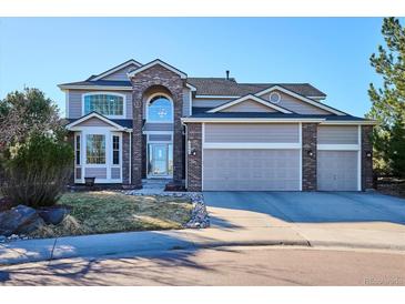Charming two-story home with a three-car garage and well-manicured front yard at 2460 Switch Grass Way, Castle Rock, CO 80109