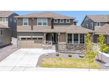 Charming two-story home showcasing stone accents, manicured lawn, and welcoming entrance at 17121 Desert Wine Ln, Parker, CO 80134