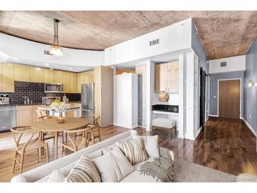 Bright open concept living room featuring a modern kitchen, a dining area, and hardwood floors at 1700 Bassett St # 502, Denver, CO 80202