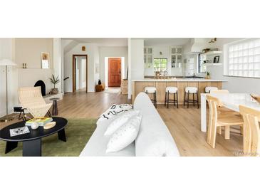 Bright living space with open layout to kitchen, features wood floors, modern decor, and ample natural light at 3445 S Clermont St, Denver, CO 80222