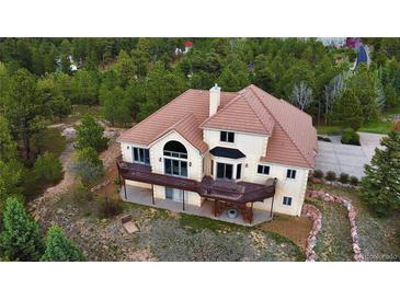 Stunning aerial view of home featuring a brown roof, stucco exterior, and a spacious deck at 1120 Brenthaven Ct, Monument, CO 80132