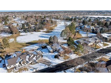 An aerial view of a snow-covered landscape shows the home and surrounding neighborhood in winter at 78 Fairway Ln, Littleton, CO 80123