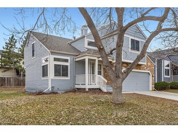 Charming home featuring a two-car garage and appealing stone and blue siding accents at 2358 Dogwood Cir, Louisville, CO 80027