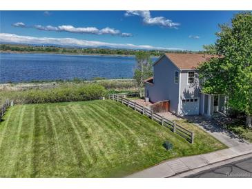 Charming home with a large, well-manicured lawn and stunning lake views at 1353 Mallard Ln, Brighton, CO 80601