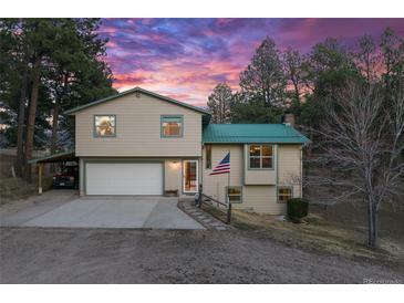 Charming two-story home with a two-car garage, car port, and manicured lawn at 34480 Pine Ridge Cir, Elizabeth, CO 80107