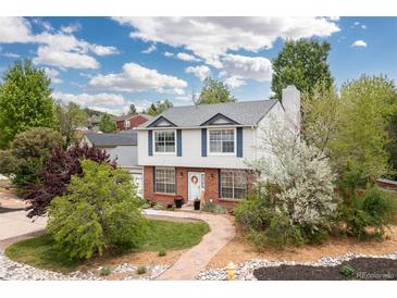 Charming two-story home featuring brick accents, a lush front yard, and a welcoming entrance at 1200 Butterfield Ln, Castle Rock, CO 80104