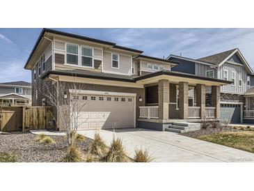 Two-story home boasting a two-car garage, covered porch with brick columns, and low maintenance landscaping at 6172 N Liverpool St, Aurora, CO 80019