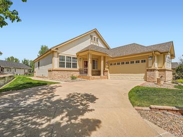 Inviting exterior with a two-car garage, a well-manicured lawn, and a long driveway at 7922 S Algonquian Way, Aurora, CO 80016
