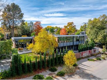Striking contemporary home with modern design, mature trees, and manicured landscaping during autumn at 101 S Humboldt St, Denver, CO 80209