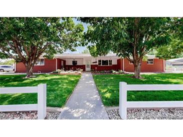 Charming brick home featuring a lush, green lawn and mature trees at 11542 W 29Th Pl, Lakewood, CO 80215