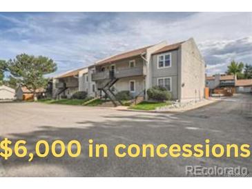 Exterior view of condominium building with gray siding and black iron stairs to upper-level units at 7165 S Gaylord St # E07, Centennial, CO 80122