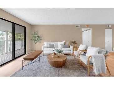 Bright living room featuring a modern design, balcony access, and neutral color palette at 921 S Walden Street # 205, Aurora, CO 80017