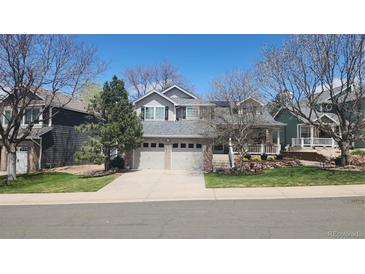 Charming two-story home with a two-car garage, well-manicured lawn, and inviting front porch at 9916 Spring Hill Ln, Highlands Ranch, CO 80129