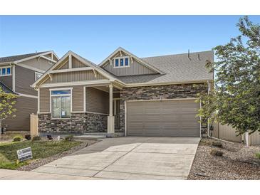 Charming two-story home with stone accents, a well-maintained lawn, and a convenient attached two-car garage at 4625 Walden Ct, Denver, CO 80249