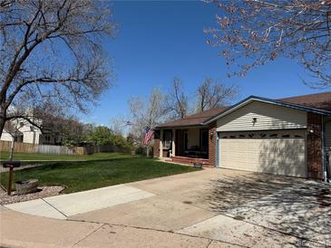 Charming single-story home features a well-manicured lawn, covered porch, and attached two-car garage at 10566 Canosa Ct, Denver, CO 80234