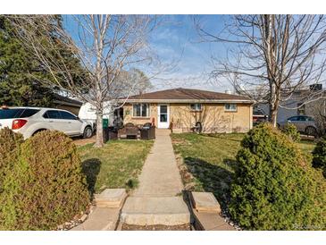 Charming brick home with a well-maintained lawn and inviting front porch seating area at 518 Cherry St, Hudson, CO 80642
