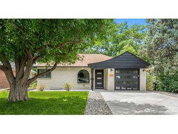 Charming ranch-style home with white brick, dark trim, and a well-manicured lawn at 1045 Locust St, Denver, CO 80220