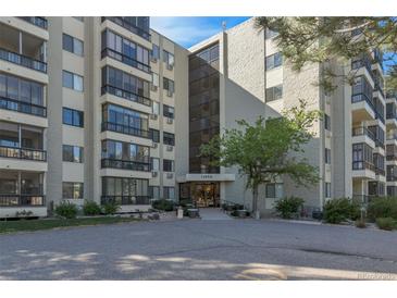 A low angle view of the building's facade shows the entryway, address, and first few stories at 13850 E Marina Dr # 506, Aurora, CO 80014