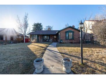 Brick ranch home with a landscaped lawn and walkway at 1475 Monaco Pkwy, Denver, CO 80220