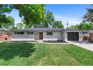 Charming single-story home featuring a well-maintained lawn, white brick exterior, dark shutters and a one-car garage at 9455 W 37Th Ave, Wheat Ridge, CO 80033