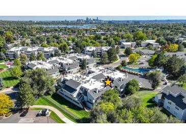 A view of the property showing its proximity to the pool, landscaping, and city skyline in the background at 1820 Newland Ct # 213, Lakewood, CO 80214