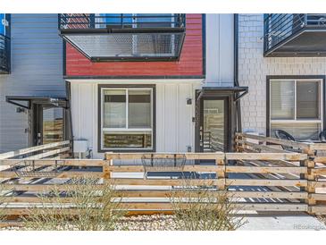 Charming townhouse exterior with a metal awning, decorative fencing and vibrant red accents at 5530 W 11Th Pl, Lakewood, CO 80214