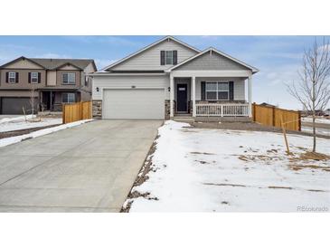 Charming home featuring a two-car garage, covered porch, and partial stone accents at 6501 14Th St, Frederick, CO 80530
